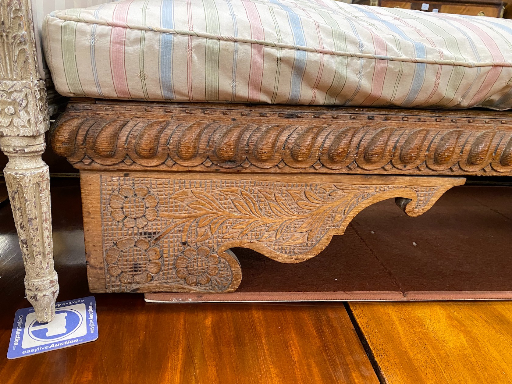 A 19th century Spanish oak low stool, length 134cm, depth 46cm, height with cushion 40cm